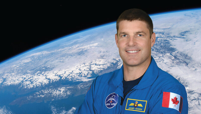Jeremy Hansen, Canadian Space Agency astronaut, in his flight suit with Earth behind him